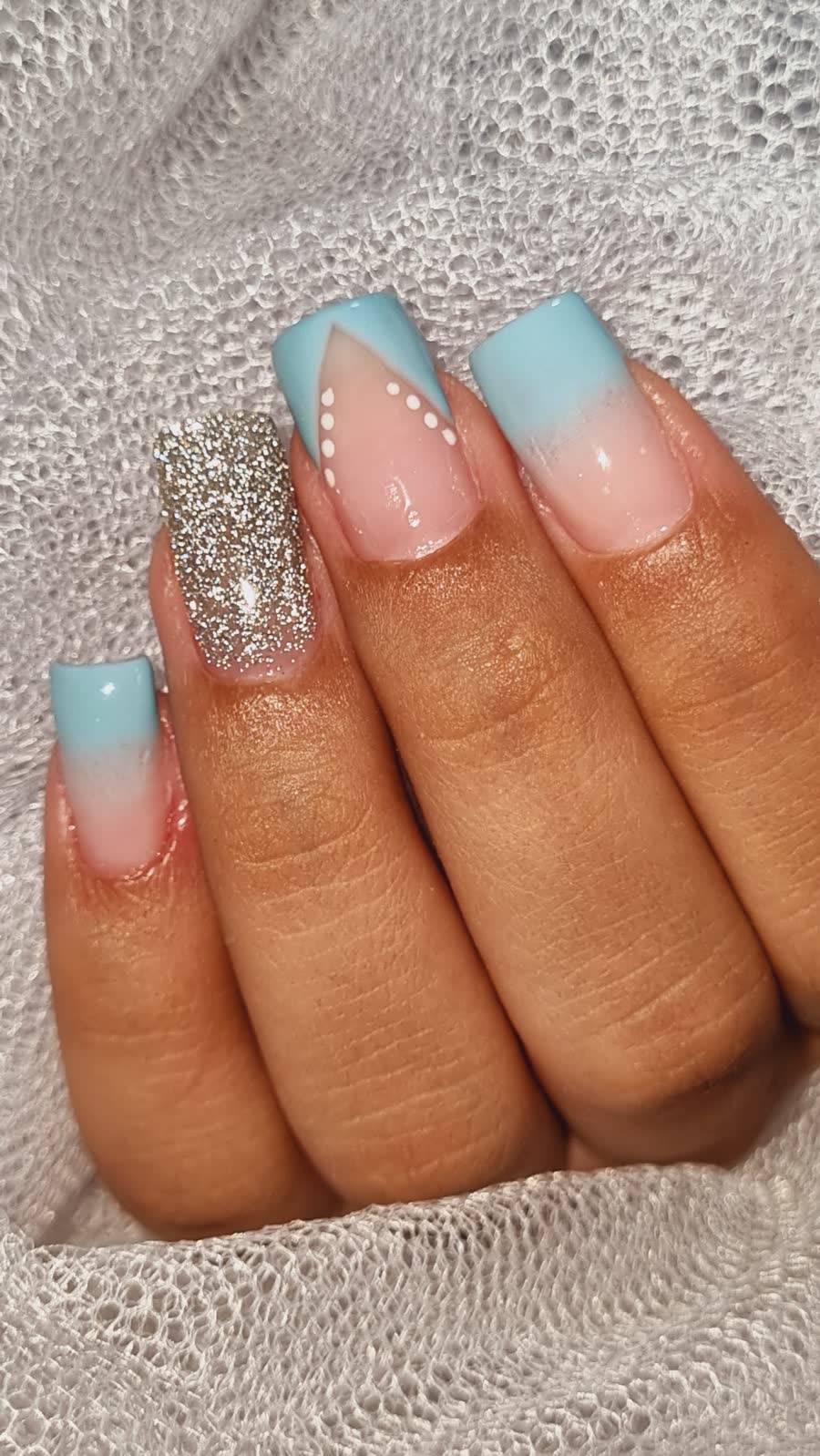 Unhas com francesinha azul e uma unha com glitter prata